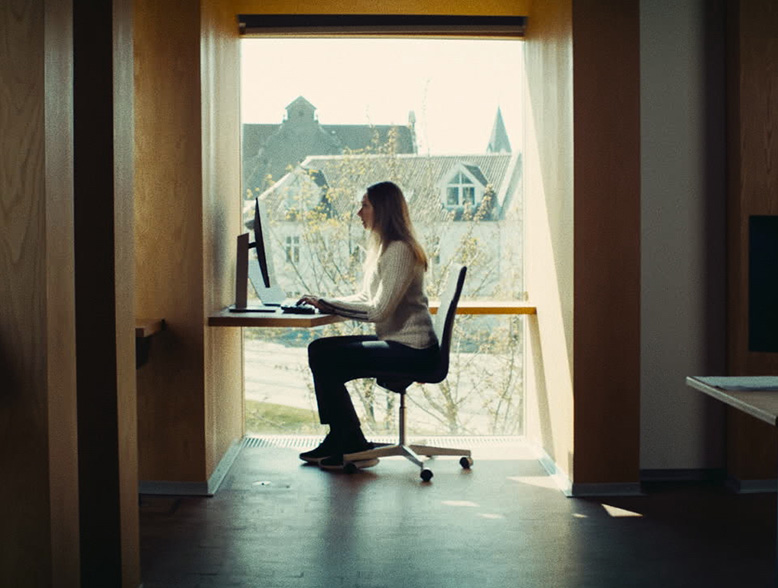 Kvinde sidder på en stol på et kontor