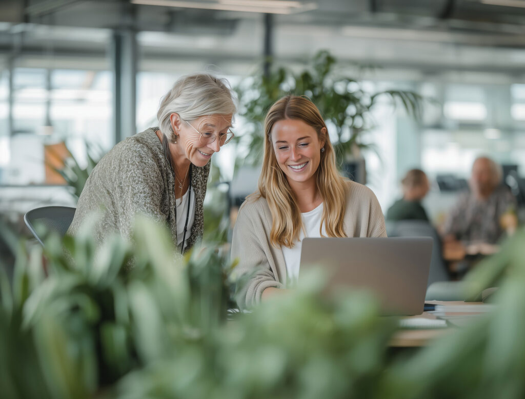 2 kvinder snakker og kigger på en computer